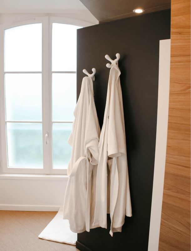 peignoirs accroch&eacute;s sur un porte serviette dans une salle de bains